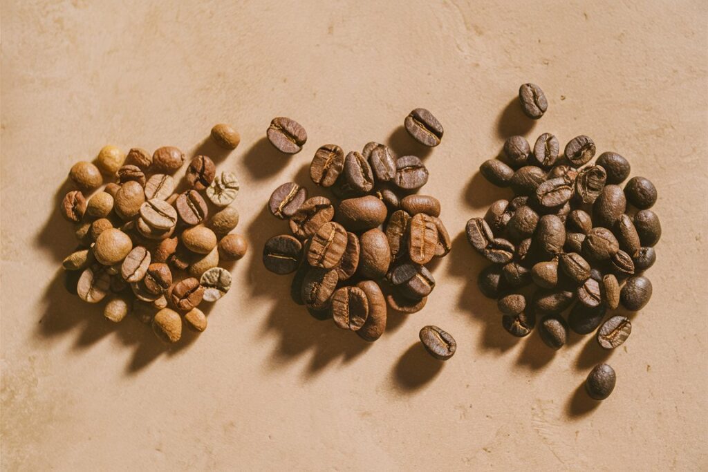 Drei verschiedene Kaffeesorten, jeweils in einem Häufchen nebeneinander angeordnet.